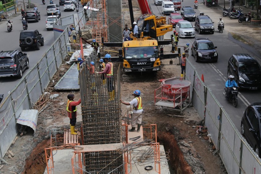 Pekerja mengerjakan pembangunan proyek kereta api ringan/Light Rail Transit (LRT) di jalan Jenderal Sudirman, Palembang, Sumatera Selatan, Senin (28/3).