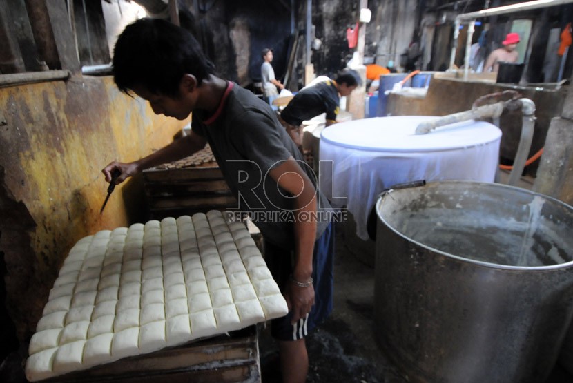  Pekerja mengerjakan pembuatan tahu berbahan kedelai impor di Duren Tiga, Jakarta, Kamis (22/8). (Republika/Aditya Pradana Putra)