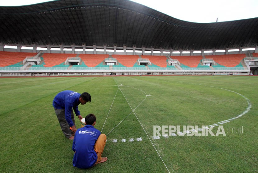 Pekerja mengerjakan perawatan rumput lapangan Stadion Pakansari di Bogor, Jawa Barat, Rabu (23/5).