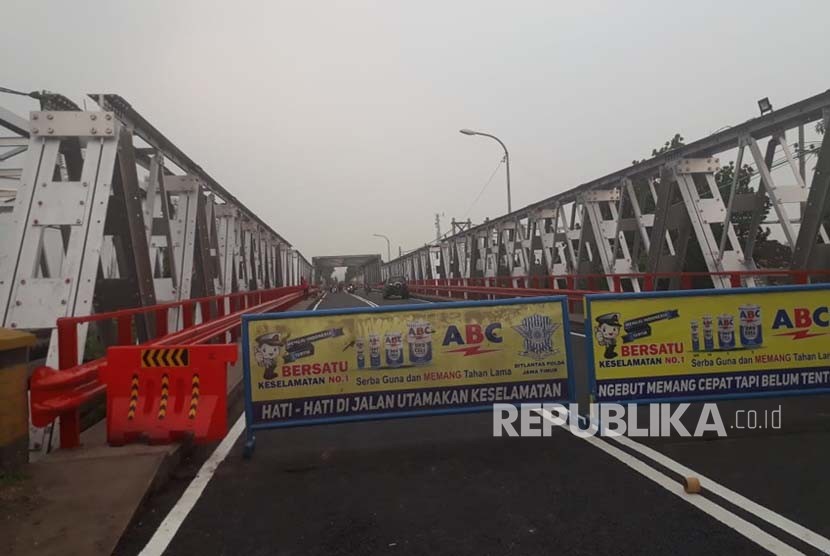 Pekerja mengerjakan proses finishing proyek perbaikan jembatan penghubung antara Widang, Tuban dengan Babat, Lamongan, Ahad (3/6
