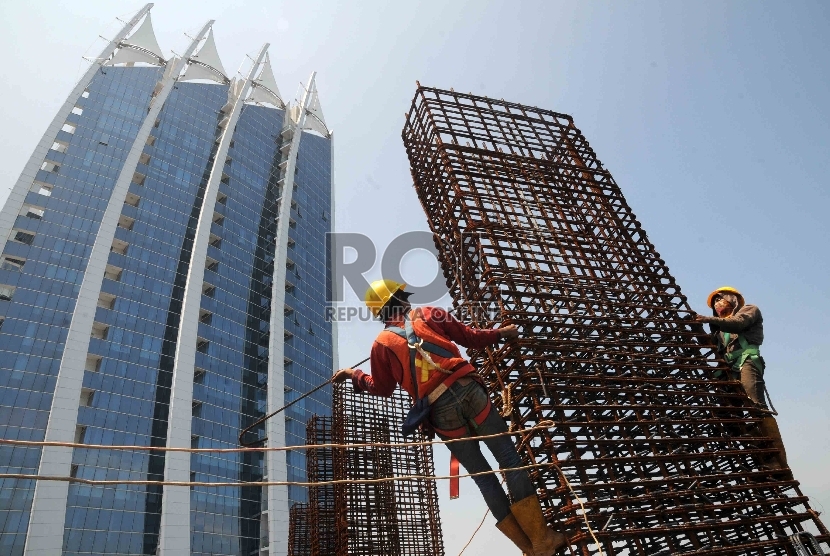 Pekerja menggarap proyek pembangunan apartemen Regatta, Pantai Mutiara, Pluit, Jakarta Utara, Kamis (7/1).