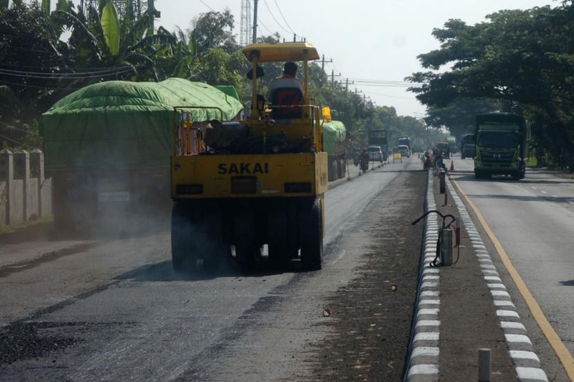 Pekerja menggunakan alat berat melakukan perbaikan jalan di Jawa Tengah (ilustrasi)