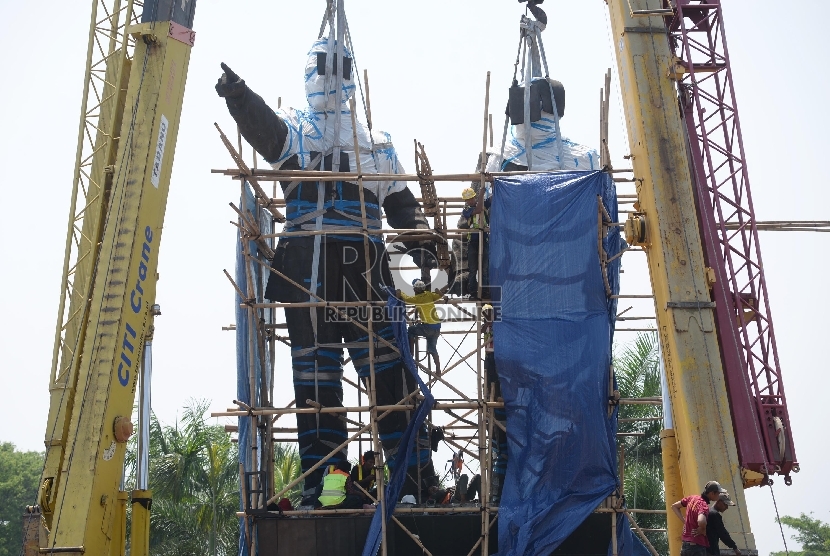 Pekerja menggunakan alat berat melakukan persiapan pemindahan Patung Proklamator Soekarno-Hatta di Jalan Raya Bandara Soekarno-Hatta, Tangerang, Banten, Kamis (7/1). 