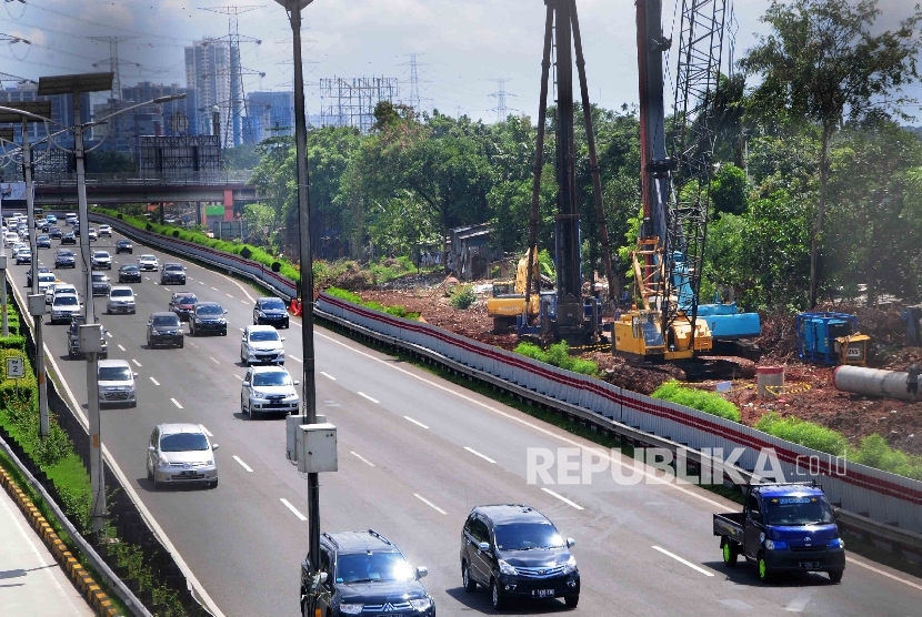 Pekerja menggunakan alat berat memasang tiang beton pada proyek pembangunan jalur kereta ringan atau Light Rail Transit (LRT) di sisi jalan Tol Cililitan, Jakarta, Ahad (17/4).  (Republika/Agung Supriyanto)