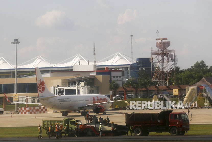 Pekerja menggunakan alat berat untuk mengaspal landasan bandara Sultan Mahmud Baddarudin (SMB) II Palembang, Sumatera Selatan, Kamis (5/4).