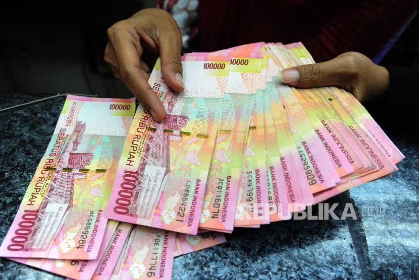 Pekerja menghitung uang rupiah di salah satu tempat penukaran, Jakarta, Jumat (2\12).