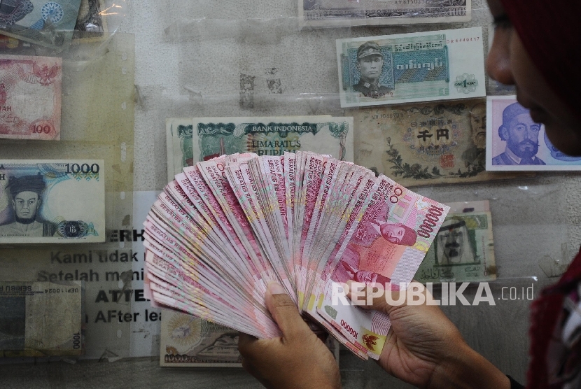  Pekerja menghitung uang rupiah di salahsatu tempat penukaran, Jakarta, Jumat (2\12).