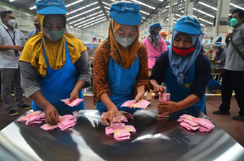 Pekerja menghitung uang Tunjangan Hari Raya (THR) yang diterimanya di pabrik rokok PT Djarum, Kudus, Jawa Tengah, Selasa (19/4/2022). Sebanyak 52.025 pekerja harian dan borongan yang tersebar di tujuh kota di perusahaan itu telah menerima uang THR guna membantu mereka dalam memenuhi kebutuhan keluarga selama bulan Ramadhan dan Idul Fitri. 