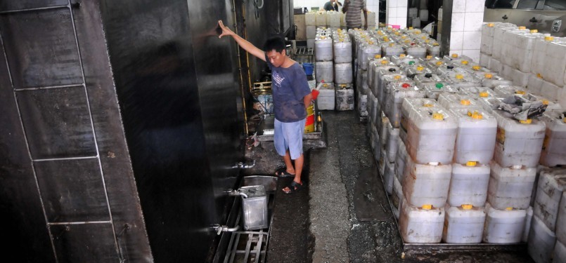 Pekerja mengisi jeriken minyak goreng curah di Pasar Tanah Abang, Jakarta, Rabu (11/1). (Republika/Wihdan Hidayat)