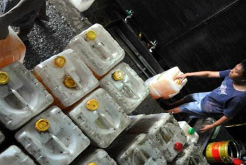 Pekerja mengisi jeriken minyak goreng curah di Pasar Tanah Abang, Jakarta, Rabu (11/1). (Republika/Wihdan Hidayat)
