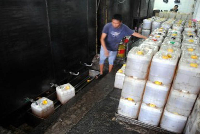 Pekerja mengisi jeriken minyak goreng curah di Pasar Tanah Abang, Jakarta, Rabu (11/1). (Republika/Wihdan Hidayat)