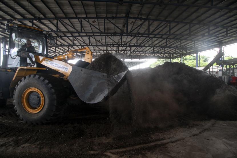 Pekerja mengoperasikan alat berat mengeruk bahan baku pengganti batu bara (co-firing) biomassa yang berasal dari sampah di Tempat Pembuangan Akhir (TPA) Sampah di Jabon, Sidoarjo, Jawa Timur, Rabu (13/7/2022). PT PLN (Persero) berkomitmen melakukan akselerasi dan transisi implementasi energi baru terbarukan (EBT) dalam rangka penurunan emisi terkait dekarbonisasi.