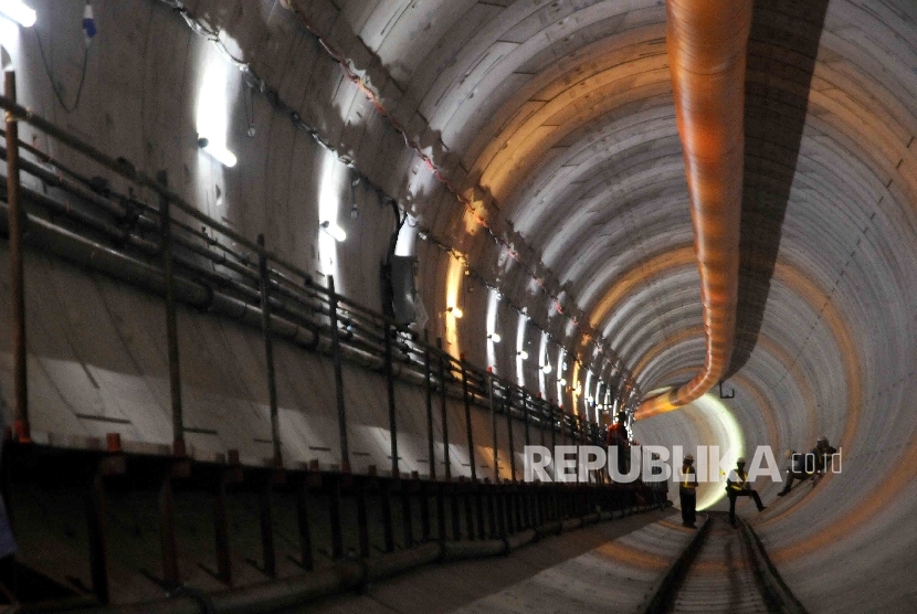 Pekerja mengukur sudut kemiringan pada proyek terowongan Mass Rapid Transit (MRT) di kawasan Senayan, Jakarta, Kamis (21/1).