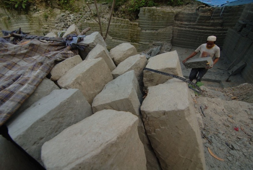 Pekerja mengumpulkan batu kumbung untuk bahan bangunan yang ditambangan di Desa Blumbungan, Larangan, Pamekasan, Jatim, Kamis (31/3). 