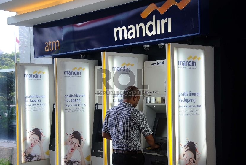  Pekerja mengunakan fasilitas pelayanan di ATM Bank Mandiri, Jakarta, Senin (19/10). 