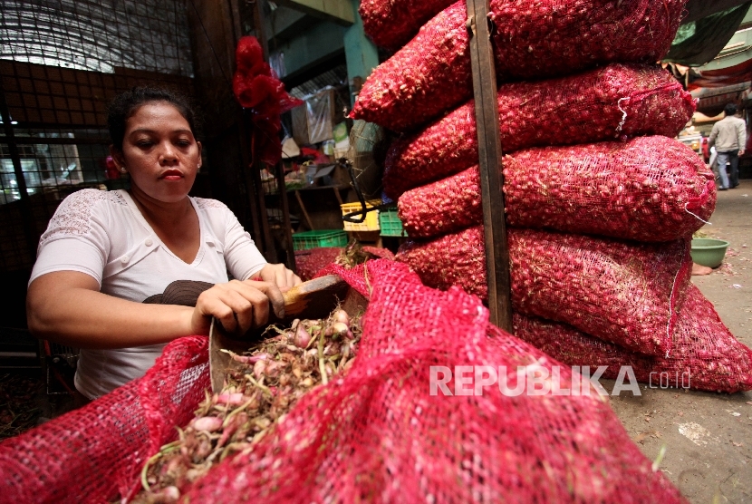 Pekerja mengupas bawang merah di Pasar Induk Kramat Jati, Jakarta, Senin (8/5).