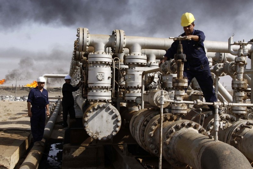Pekerja menjaga kilang minyak di Basra, Iraq.