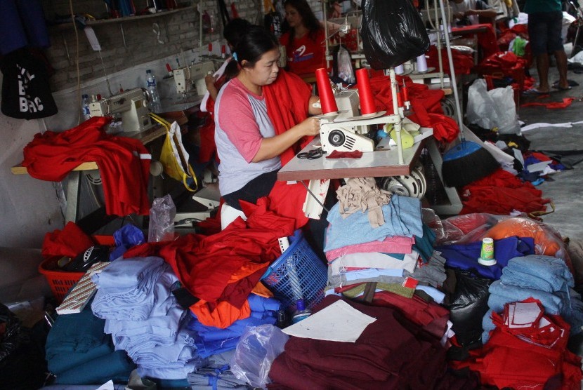 Pekerja menjahit pakaian di salah satu industri tekstil rumahan di Lesanpuro, Malang, Jawa Timur, Jumat (7/7). 