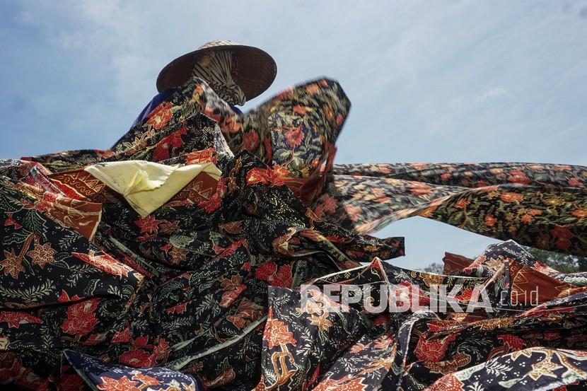 Pekerja menjemur kain batik sepanjang sekitar 125-250 meter di Medono, Pekalongan, Jawa Tengah (22/9/2021). (Ilustrasi)