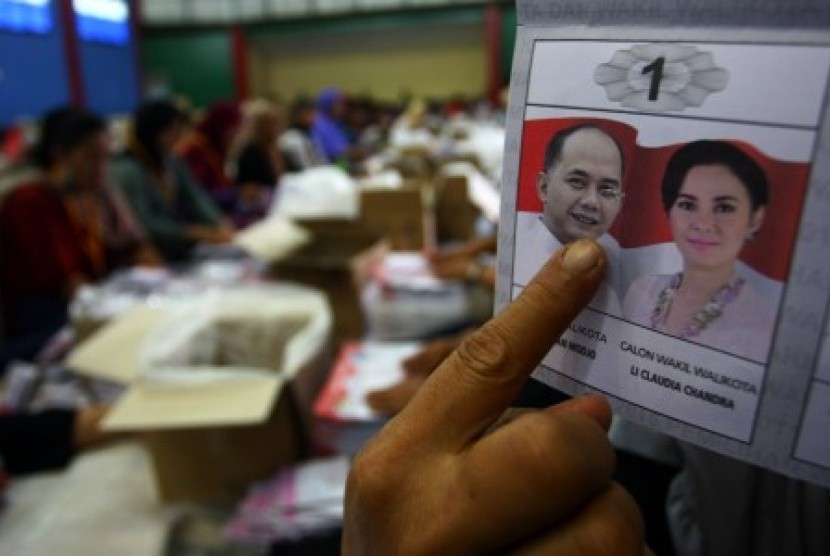 Pekerja menunjukan surat suara yang rusak ketika melakukan pelipatan kertas suara untuk Pemilukada Kota Tangerang Selatan di Gelanggang Olahraga Pd Aren, Tangerang Selatan, Banten, Rabu (25/11).