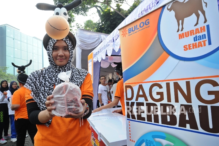 Pekerja menunjukkan daging kerbau saat kampanye pangan di Jakarta.
