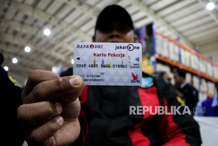 Pekerja menunjukkan Kartu Pekerja saat pendistribusian dan uji coba di Jakgrosir, Pasar Induk Kramat Jati, Jakarta, Senin (31/12/2018). 