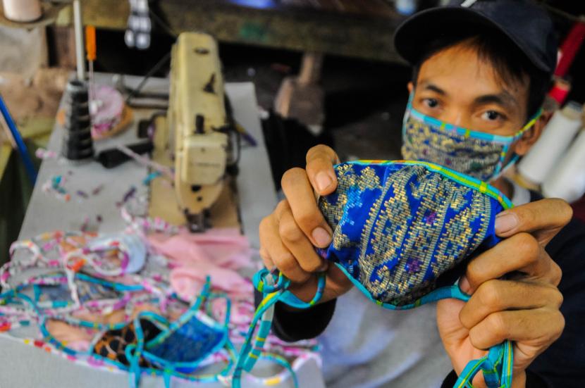 Pekerja menunjukkan masker kain produksi penjahit konveksi di Kampung Cibangkur, Lebak, Banten, Senin (6/4/2020). Tingginya permintaan masker membuat penjahit konveksi di daerah tersebut dapat memproduksi 500-1000 lembar masker kain per hari dengan harga Rp5.000 per lembarnya, dan dipasarkan ke sejumlah kota seperti Serang, Cilegon, Tangerang, dan Jakarta.