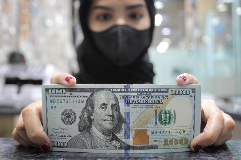 Pekerja menunjukkan uang dolar AS di salah satu gerai penukaran mata uang di Jakarta. Kementerian Keuangan memperbarui kurs pajak periode 25 Mei sampai 31 Mei 2022. Adapun keputusan ini tertuang Peraturan Menteri Keuangan No 26/KM.10/2022, kurs 1 dolar Amerika Serikat ditetapkan sebesar Rp 14.682 .