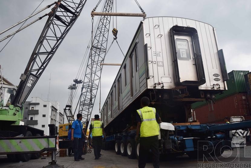 Pekerja menurunkan gerbong KRL asal Jepang ke bantalan rel di Stasiun Pasoso, Pelabuhan Tanjung Priok, Jakarta Utara, Jumat (5/12).   (Republika/Rakhmawaty La