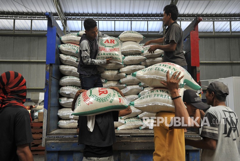 Pekerja menurunkan karung berisi beras kualitas premium dari truk di Gudang Bulog. ilustrasi