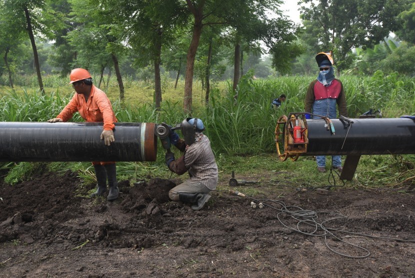 Pekerja menyambung pipa penyaluran gas pada proyek pembangunan pipa transmisi gas ruas Porong - Grati milik Pertamina Gas (Pertagas) di Pasuruan, Jawa Timur.