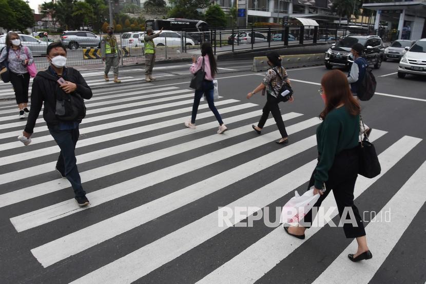 Pekerja menyeberang di pelican cross Tosari saat jam pulang kerja di Jakarta, Rabu (17/11/2021). Menteri Ketenagakerjaan Ida Fauziyah memastikan rata-rata kenaikan upah minimum provinsi (UMP) pada tahun 2022 secara nasional sebesar 1,09 persen. 