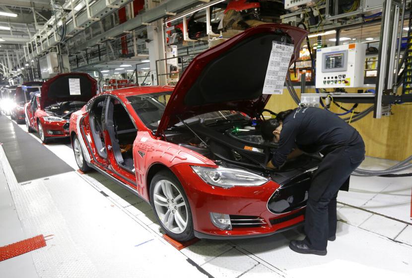 Pekerja menyelesaikan kendaraan di pabrik Tesla di Fremont, California, Amerika Serikat, beberapa waktu lalu. Tesla mengancam akan memindahkan pabriknya dari California karena tidak diizinkan membuka kembali pabrik di tengah aturan lockdown.