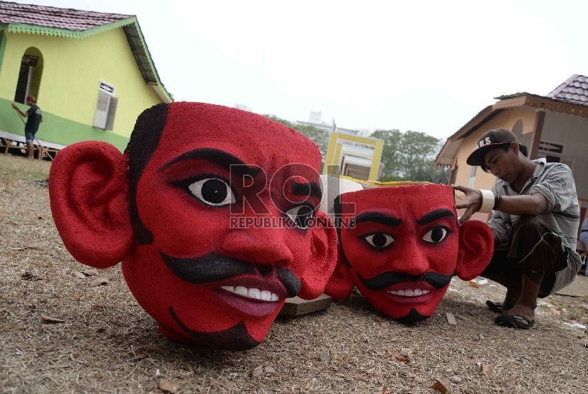   Pekerja menyelesaikan patung ondel-ondel Betawi di lokasi Festival Lebaran Betawi VIII, di Lapangan Banteng, Jakarta, Kamis (20/8).