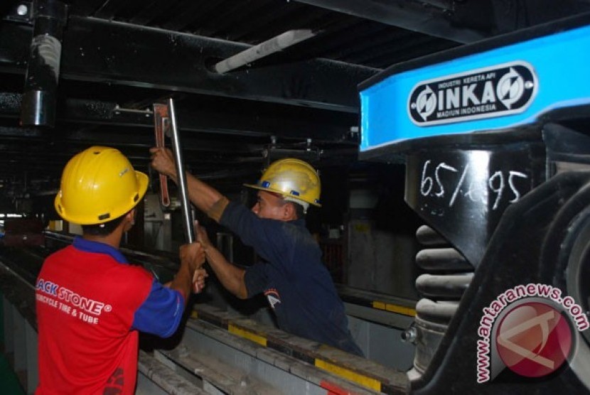 Pekerja menyelesaikan pekerjaan bagian bawah kereta di Industri Kereta Api (Inka) Madiun, Jatim, Rabu (11/7)