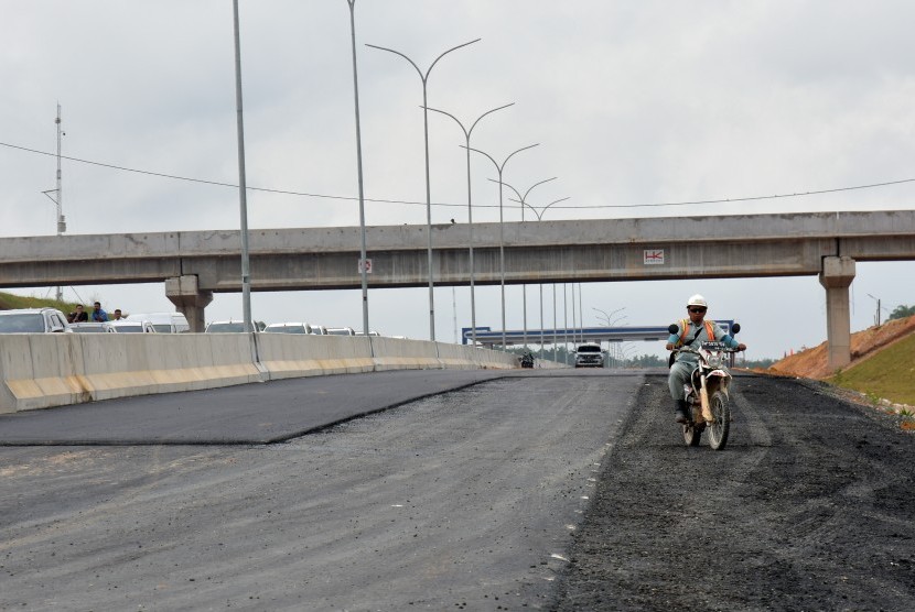 Pekerja menyelesaikan pekerjaan pembangunan jalan tol Pekanbaru-Dumai Seksi 1 di Provinsi Riau, Rabu (30/1/2019).
