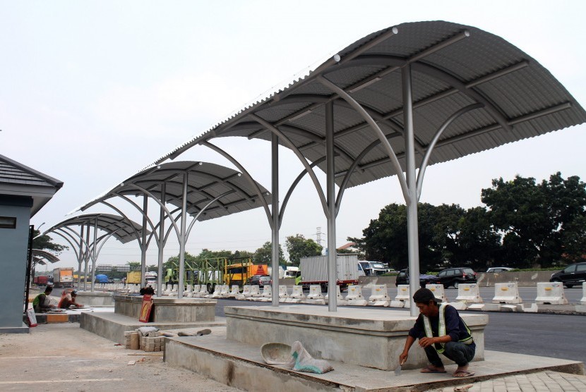 Pekerja menyelesaikan pembangunan area kantong parkir raksasa (Parking Bay) di Jalan Tol Jakarta-Cikampek km 18, di Tambun Selatan, Kabupaten Bekasi, Jawa Barat, Rabu (24/5). 