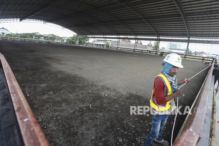 Pekerja menyelesaikan pembangunan arena Pacuan Kuda atau Equestrian di Jakarta Internasional Equestrian Park Pulomas (JIEPP), Pulomas, Jakarta, Kamis (8/3).