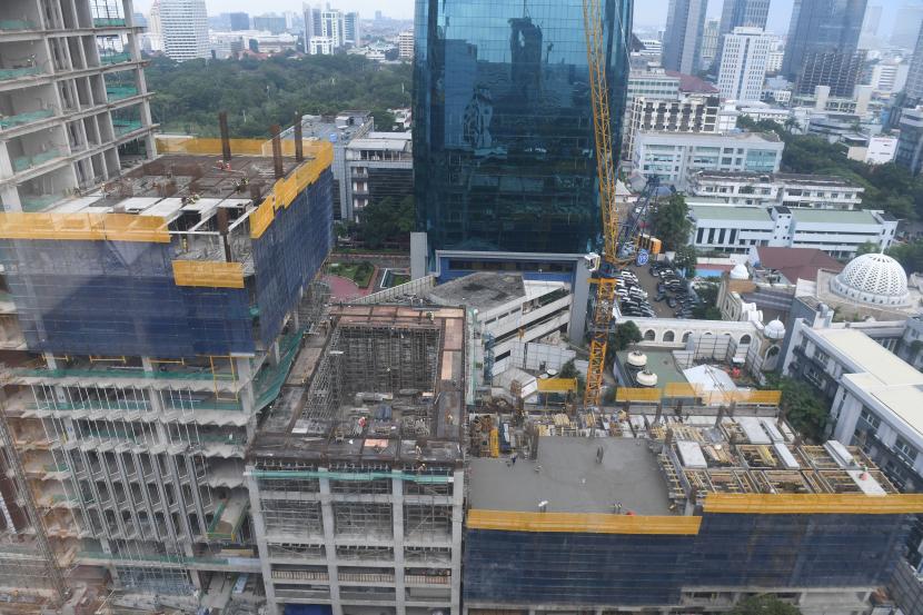 Pekerja menyelesaikan pembangunan gedung bertingkat di Jakarta, Jumat (21/1/2022). Deputi Gubernur Bank Indonesia (BI) Dody Budi Waluyo menilai normalisasi kebijakan dalam strategi keluar atau exit strategy harus terencana dengan baik untuk menjaga stabilitas. 