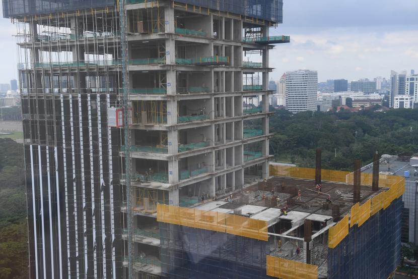 Pekerja menyelesaikan pembangunan gedung bertingkat di Jakarta, Jumat (21/1/2022). Dana Moneter Internasional (IMF) memangkas proyeksi ekonomi Indonesia pada 2022 menjadi 5,6 persen, dari perkiraan sebelumnya sebesar 5,9 persen. 