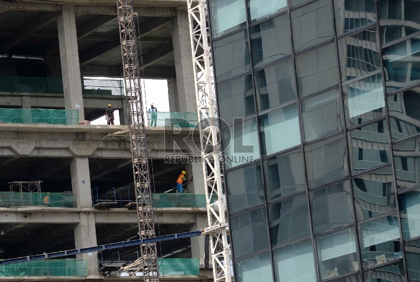  Pekerja menyelesaikan pembangunan gedung bertingkat di pusat perekonomian, Jakarta, Selasa (27/1) (Republika/Raisan Al Farisi)