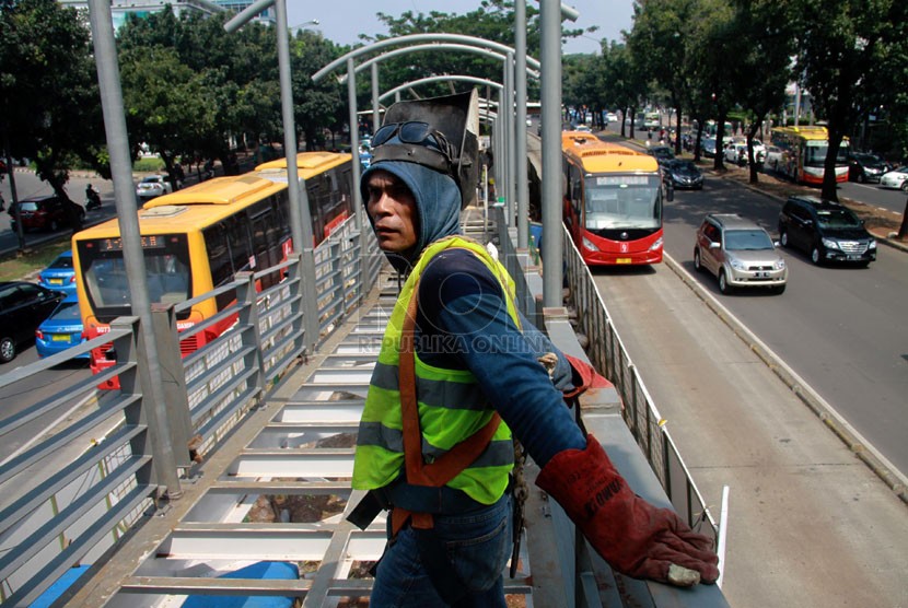   Pekerja menyelesaikan pembangunan Halte TransJakarta Bundaran Senayan yang baru di Jalan Sudirman, Jakarta Pusat, Senin (2/6). (Republika/Yasin Habibi)