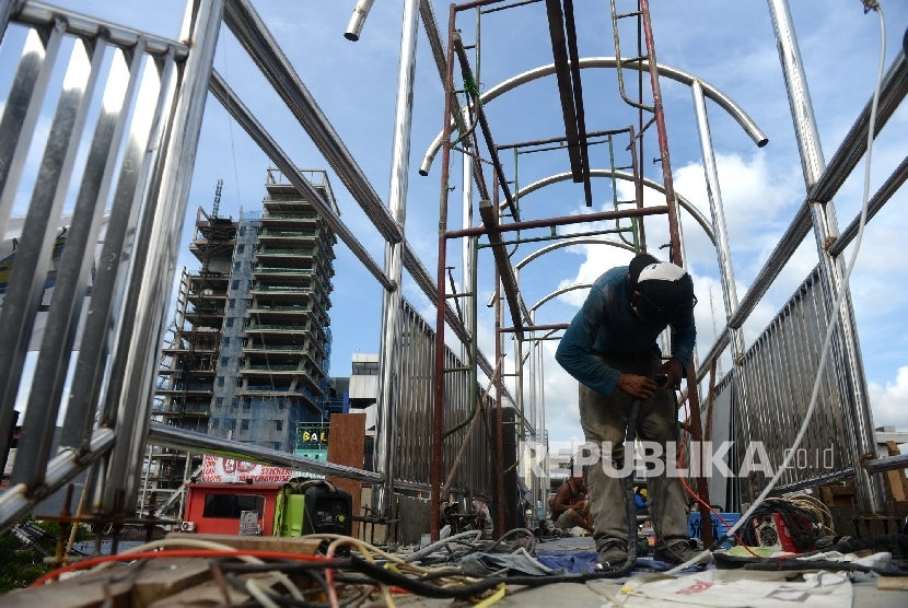 Pekerja menyelesaikan pembangunan jembatan penyeberangan orang (JPO) di kawasan Margonda, Depok, Jawa Barat, Rabu (14/12).