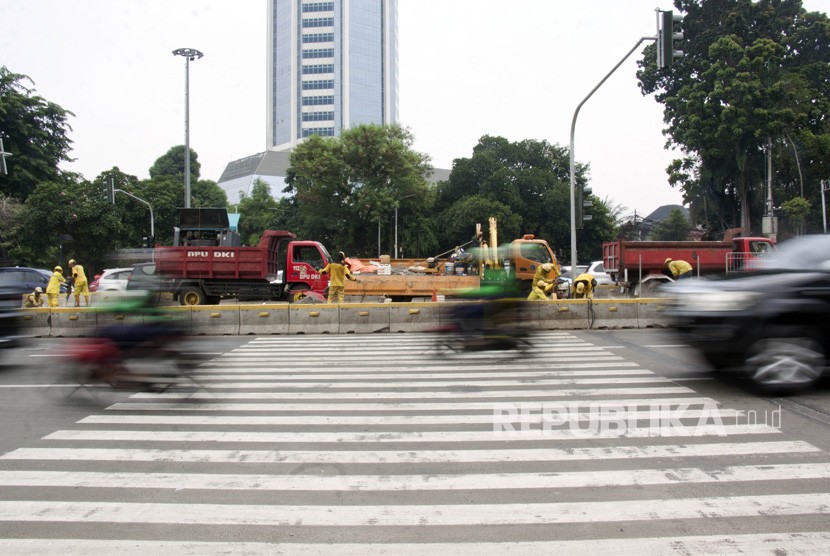 Pekerja menyelesaikan pembangunan 'pelican crossing' di kawasan Tosari, Jalan Sudirman, Jakarta, Ahad (9/12/2018).