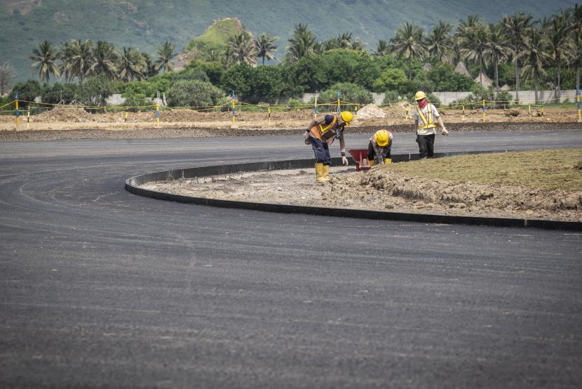 Pekerja menyelesaikan pembangunan proyek Mandalika International Street Circuit di Kawasan Ekonomi Khusus (KEK) Mandalika, Pujut, Praya, Lombok Tengah, Nusa Tenggara Barat, Kamis (4/3/2021). Berdasarkan data Mandalika Grand Prix Association (MGPA), ITDC dan PT PP per Februrari 2021 progres pembangunan lintasan sirkuit MotoGP itu secara kumulatif mencapai 53,27 persen dan ditargetkan selesai pada pertengahan 2021.