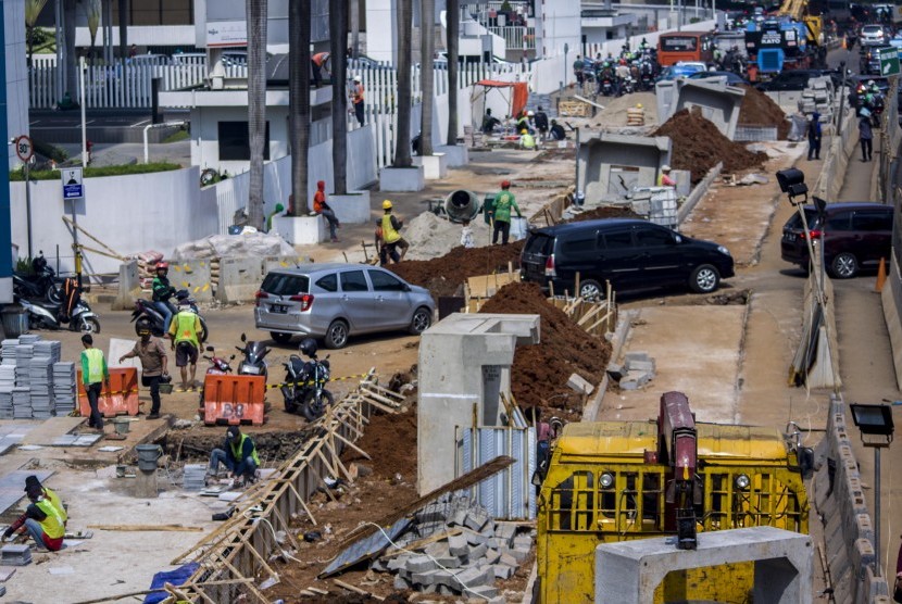 Pekerja menyelesaikan pembangunan trotoar di Jalan Sudirman, Jakarta, Rabu (4/7). 