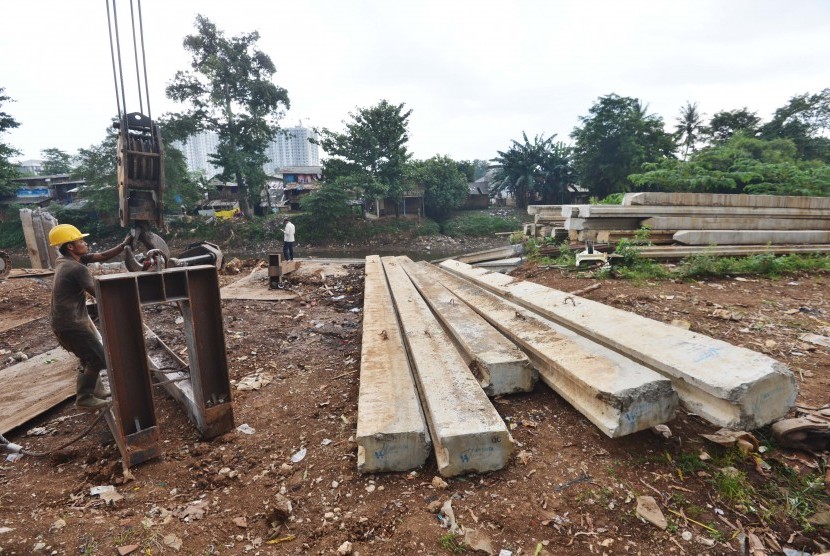 Pekerja menyelesaikan pembangunan turap Sungai Ciliwung di kawasan Kalibata, Jakarta, Senin (26/12). 