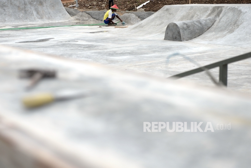 Pekerja menyelesaikan pembuatan arena permainan bmx dan skateboard di lahan bekas Kalijodo, Jakarta, Selasa (29/11)