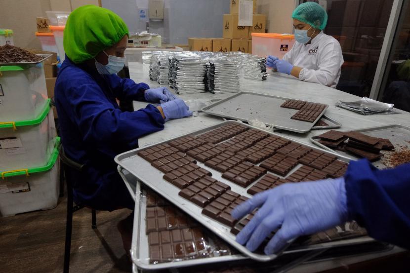 Pekerja menyelesaikan pembuatan cokelat pesanan yang akan dikirim ke negara Qatar di Cau Chocolates, Tabanan, Bali, Ahad (28/2/2021). Pabrik yang menyajikan olahan cokelat berbahan baku buah kakao dari petani lokal tersebut memproduksi cokelat untuk diekspor ke luar negeri pada masa pandemi COVID-19. 