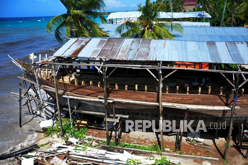 Pekerja menyelesaikan pembuatan kapal pinisi di Kecamatan Bonto Bahari, Kabupaten Bulukumba, Sulawesi Selatan, Kamis 27/5/2021). Pembuatan kapal pinisi di daerah tersebut membutuhkan waktu dua hingga tiga tahun untuk satu kapal dengan menggunakan sepuluh pekerja.